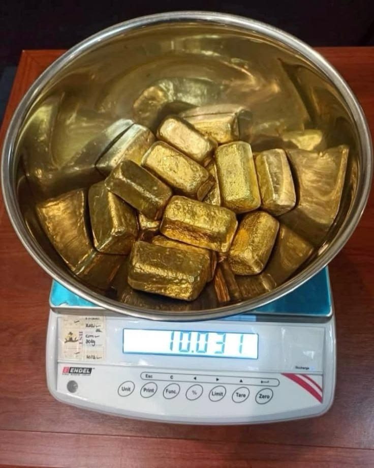 Smelted gold bars being weighed on a digital scale